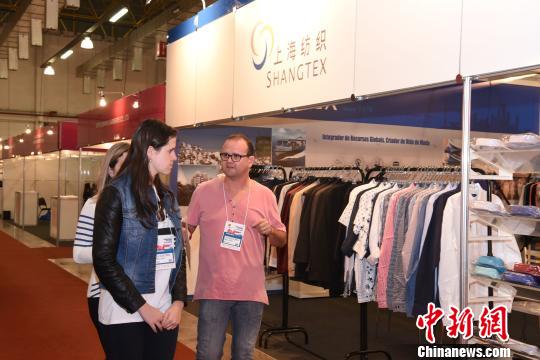 圖為外國客商在一家中國上海紡織企業展臺前走過?！∧尚邸z